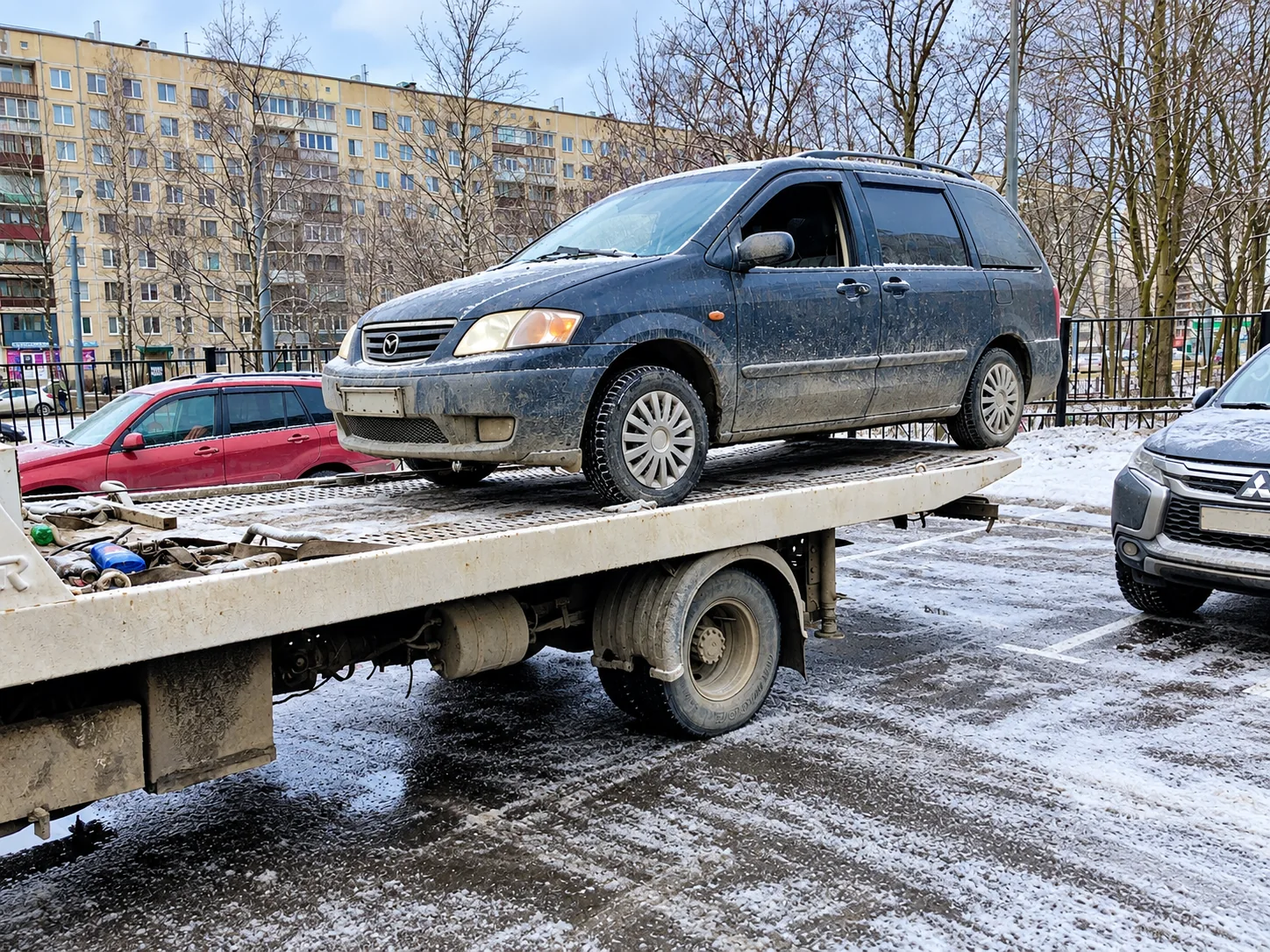 Эвакуатор с минивэном на городской парковке