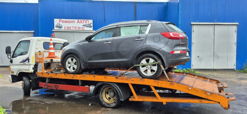 Эвакуатор загружает неисправную Kia Sportage после того, как машина заглохла