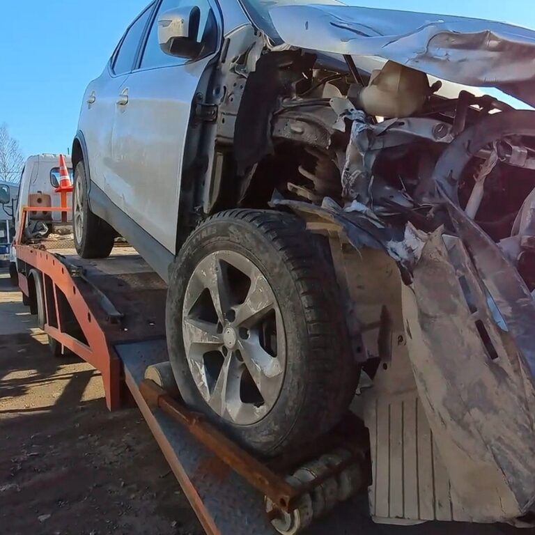 Эвакуатор загружает поврежденный автомобиль после ДТП
