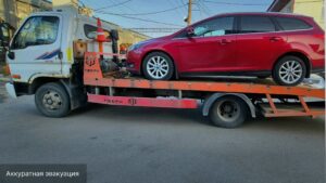 Эвакуация красного автомобиля после поломки на Суздальском проспекте в Санкт-Петербурге